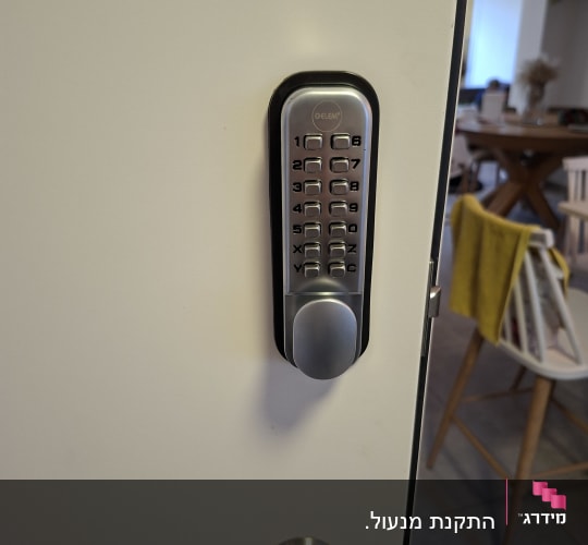 מנעול דלת עם לוח מקשים על דלת לבנה